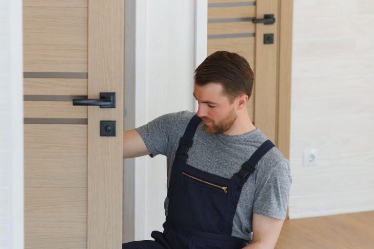 Installation of a lock on the front wooden entrance door. Portrait of young locksmith workman in blue uniform installing door knob. Professional repair service. Maintenance Concept. SSUCv3H4sIAAAAAAAACoRSTY/bIBC9V+p/iDivVdsYB++xPa20Un9A1cMYcIKCIeJjq2qV/17AJiJVV70xb2bezLzH++dPhwOawUmGng/vKYqxVCo4b8FLoyPcPu24FZoLWyNvFo9tDYCsI8GlN1aCqsEZPDtrWEUEdVAqwbecRM6DD064ahduBazOy1yOq1oGXpwi+UN1ueTHFh9KIidjR0yhr0EqLvXJfXkFzVewF4eeqjIX5lT2PXhujEUls439gPNF86RYuvQfVN+MjsnAsp53vu3x867cSWj2O91yq660QgnYFNlvQuw4gCA9a4aBLM3QwdRMU780ZOJLOyw9ocsxT9mo0eWXF3bNKu2kELg0lWpvhoFyf+l7tZJFlao248/Z/dLGTNDeppVRuRopY64wq2TWEjlFwc/gXCznBa+NjMqZtZqjjc8H76yIR6dT2GGMO9xTQscOU4LxuBds3+YsI09epywYrsoAF2no3bPHD9WNdKRDG/m2fDE5ObdK7//bSwbajXvvw0c27CL5hx8Z9bTr25aSKTu1d8k0DXFK+mU84macSNsMwKdmFrRt5lmwmfOOQs9i1+0PAAAA//8DAFZSEoi8AwAA